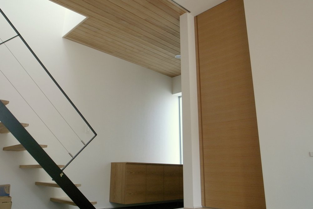 ステンレスカウンターや格子のエアコンパネルのあるタモのモダンな家具