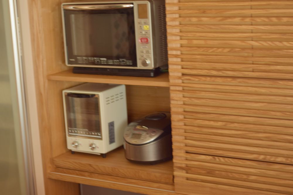 タモを使った和風な印象のカウンター下収納と格子の引き戸のある食器棚