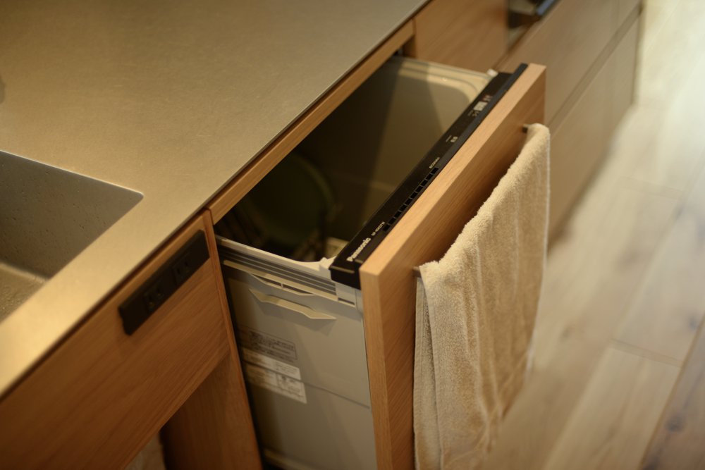 厚み5mmのステンレスバイブレーションカウンターとオークランダム張り突板を使ったアイランドキッチンと、キッチンバックボードとリビングボード