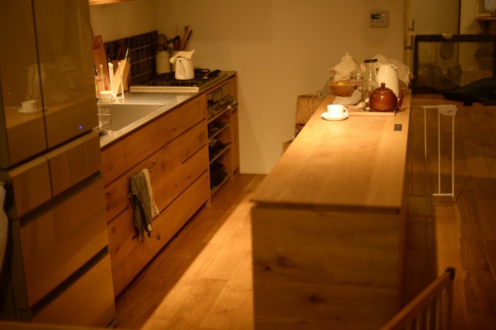 ナラ節アリ材とステンレスを使った壁付けオーダーキッチンとアイランド食器棚