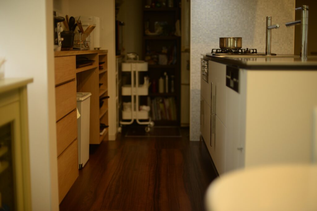 ナラ板目のカップボードとオープン棚とキッチンとの距離