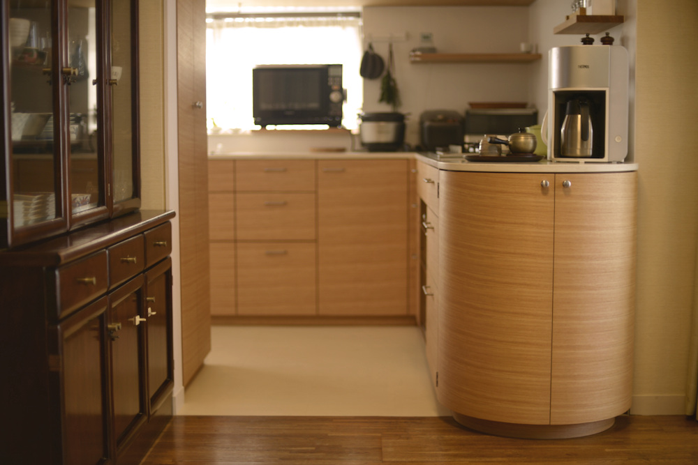 タモ柾目とコーリアンのアール扉のあるL型キッチン