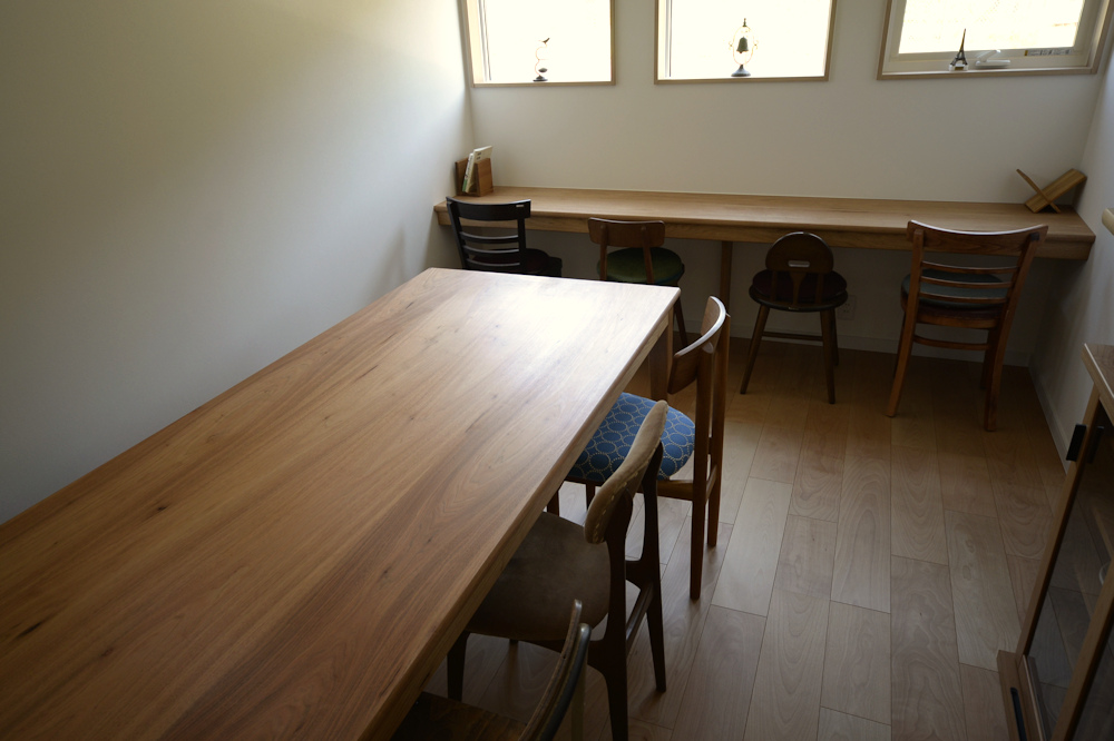 カフェ店内に置かれたクルミのテーブルとカウンター